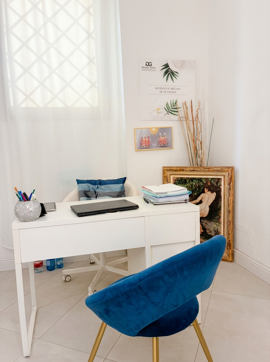 Angolo consulenza dello studio Aquamarina con scrivania bianca e poltrona blu